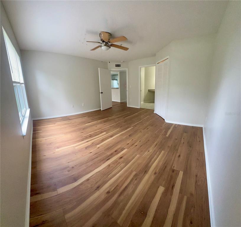 413 Summit Ridge Place, Unit 115 Longwood, FL 32779 - Photo 18 of 44 a view of empty room with wooden floor and fan