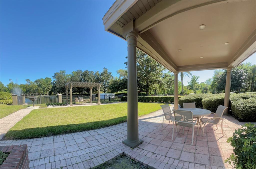 413 Summit Ridge Place, Unit 115 Longwood, FL 32779 - Photo 32 of 44 a view of a patio with dining table and chairs with a swimming pool