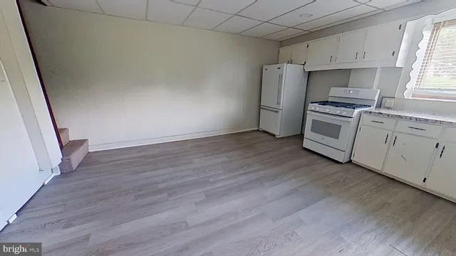 a kitchen with granite countertop a refrigerator and a stove top oven