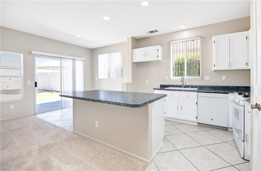 43850 Tiber Street Hemet, CA 92544 - Photo 17 of 39 a kitchen with granite countertop a sink white cabinets and a window