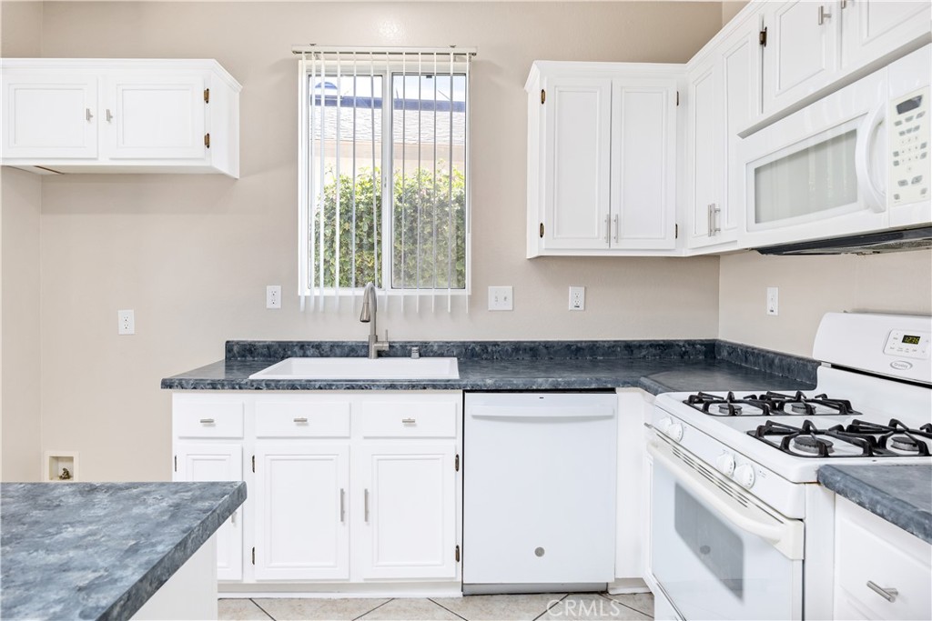 43850 Tiber Street Hemet, CA 92544 - Photo 18 of 39 a kitchen with granite countertop a sink a stove and cabinets
