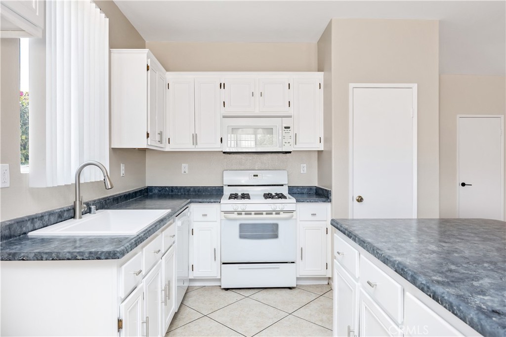 43850 Tiber Street Hemet, CA 92544 - Photo 20 of 39 a kitchen with granite countertop white cabinets and white appliances