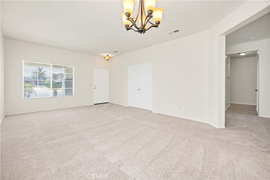 43850 Tiber Street Hemet, CA 92544 - Photo 9 of 39 an empty room with windows and chandelier fan