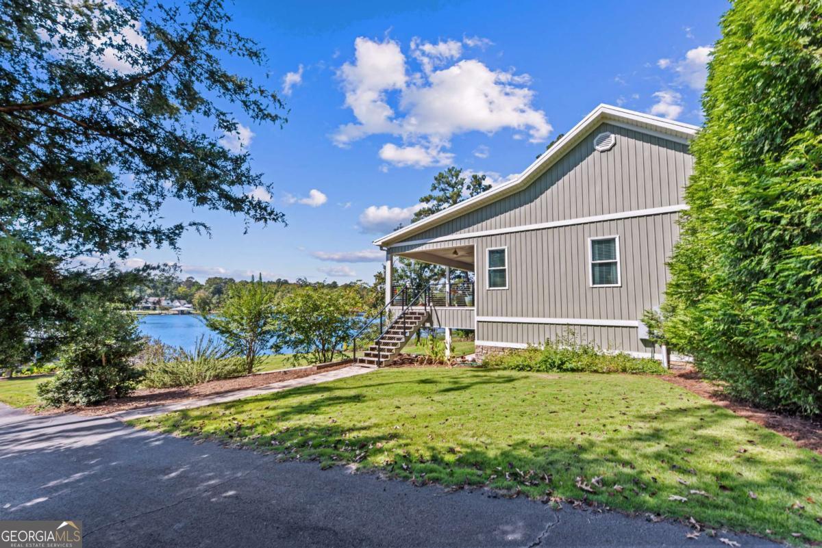 114 Sinclair Lane Eatonton, GA 31024 - Photo 53 of 76 a front view of house with yard and trees in the background