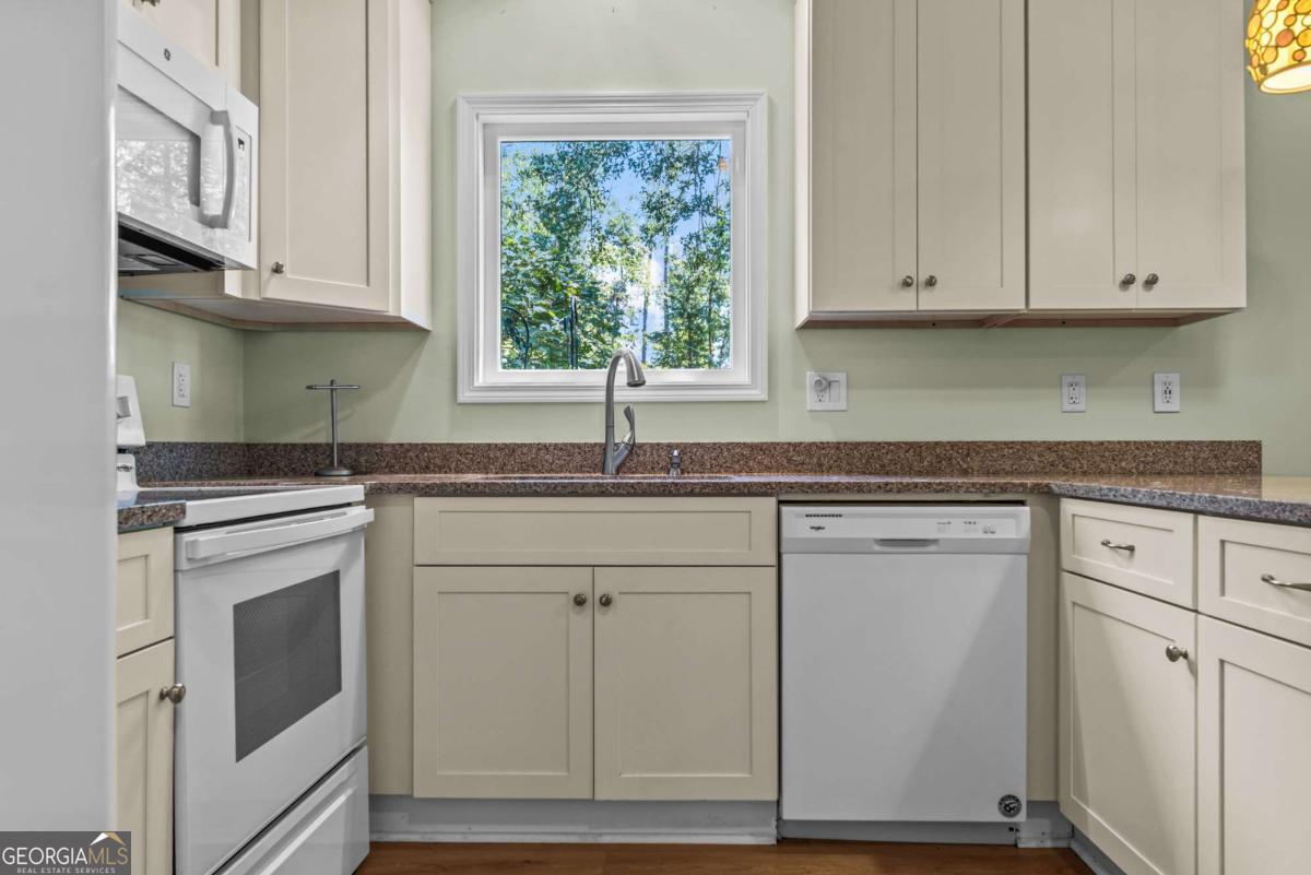 114 Sinclair Lane Eatonton, GA 31024 - Photo 70 of 76 a kitchen with stainless steel appliances granite countertop white cabinets and window