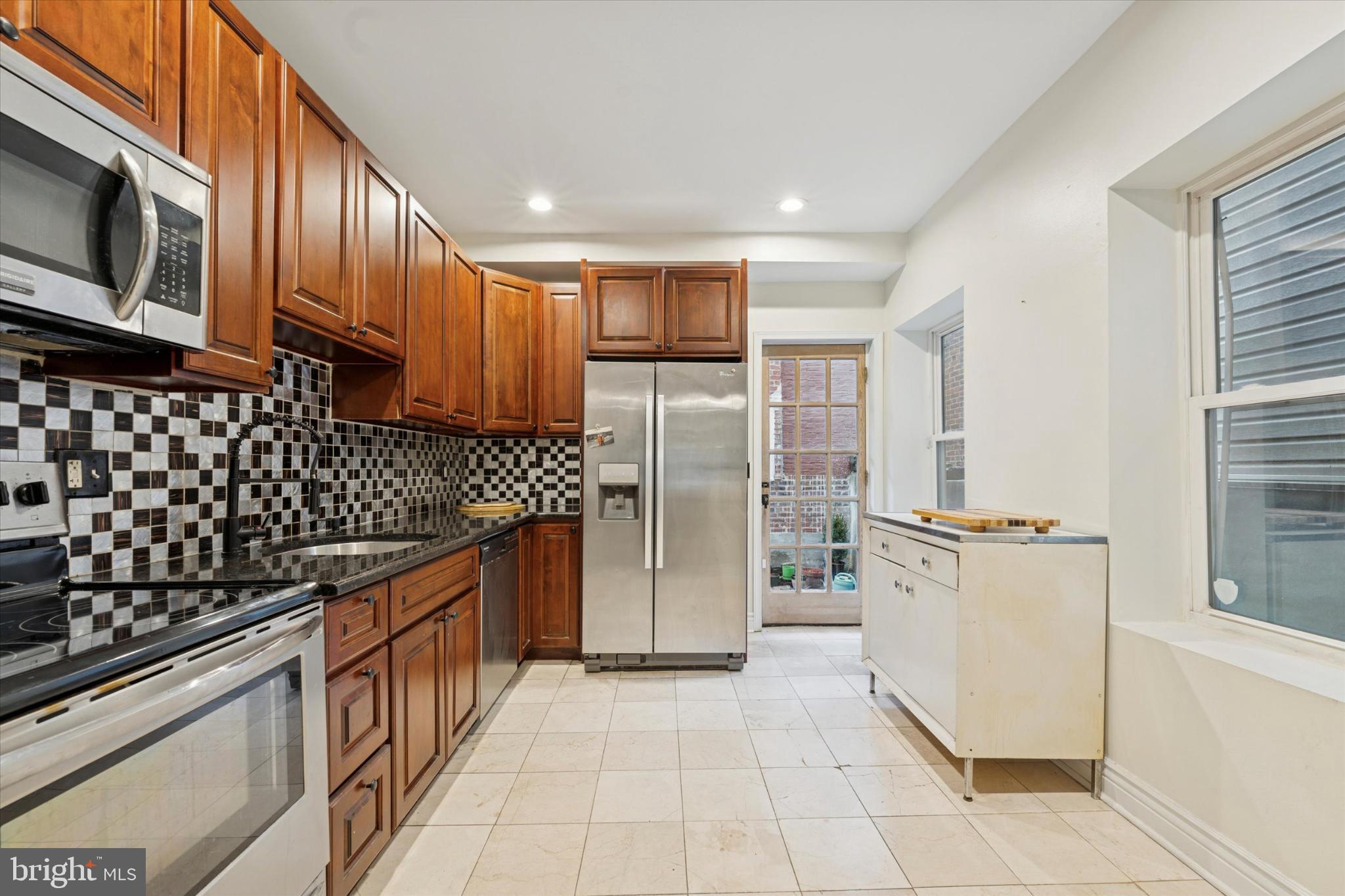 2540 Collins Street Philadelphia, PA 19125 - Photo 6 of 15 a kitchen with stainless steel appliances granite countertop a refrigerator and a stove top oven