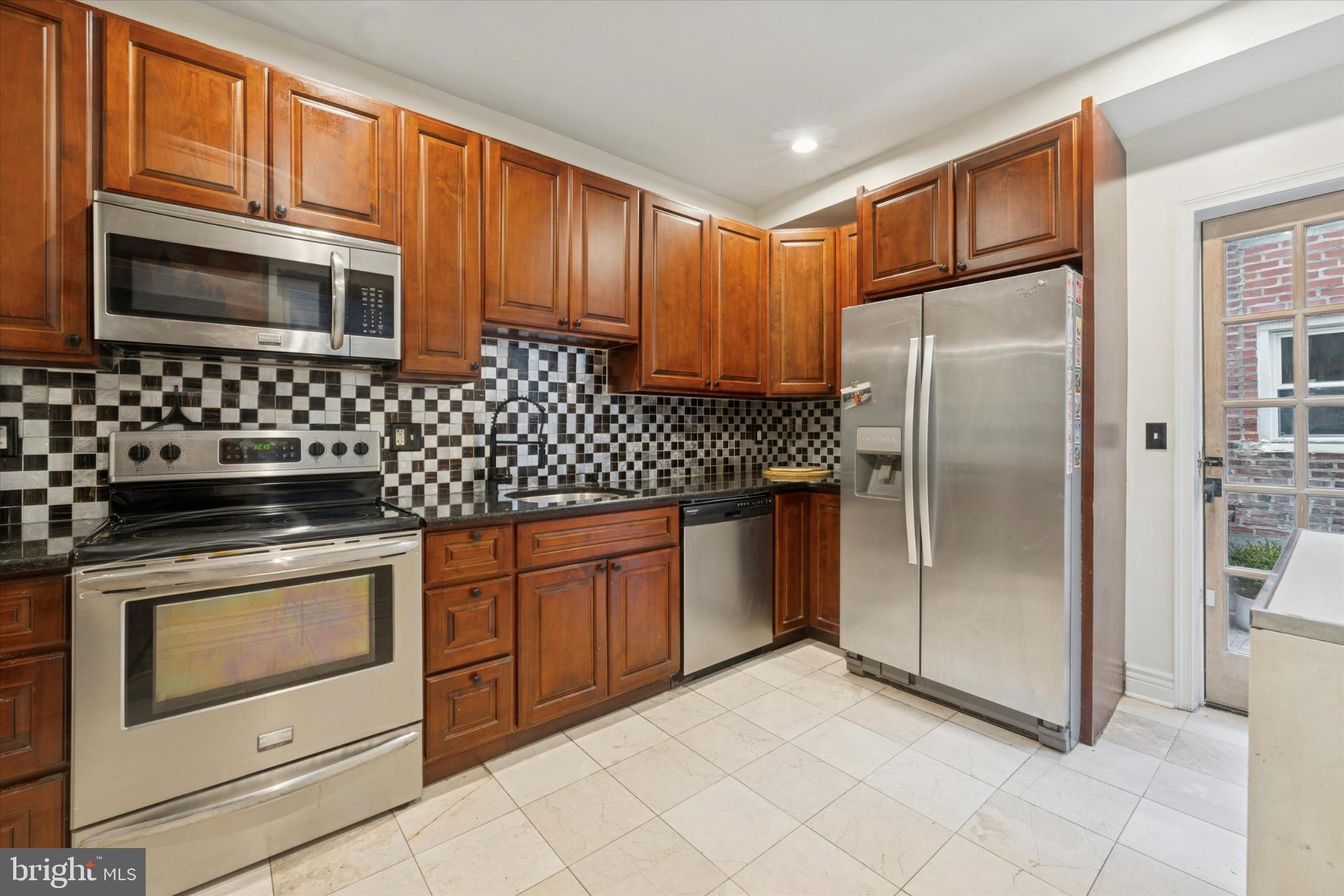 2540 Collins Street Philadelphia, PA 19125 - Photo 7 of 15 a kitchen with stainless steel appliances granite countertop a refrigerator stove and sink