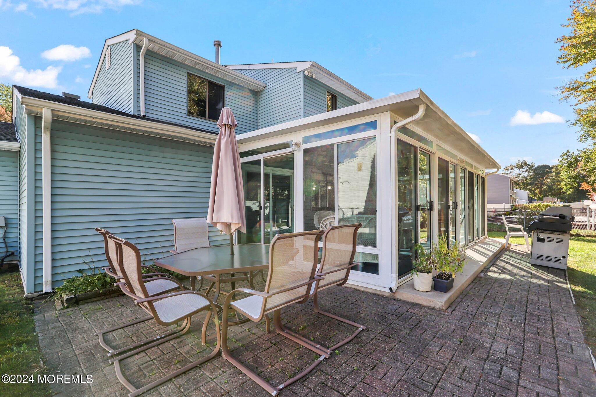 14 Cherry Bend Drive Howell, NJ 07731 - Photo 25 of 47 a view of a patio with table and chairs and floor to ceiling window