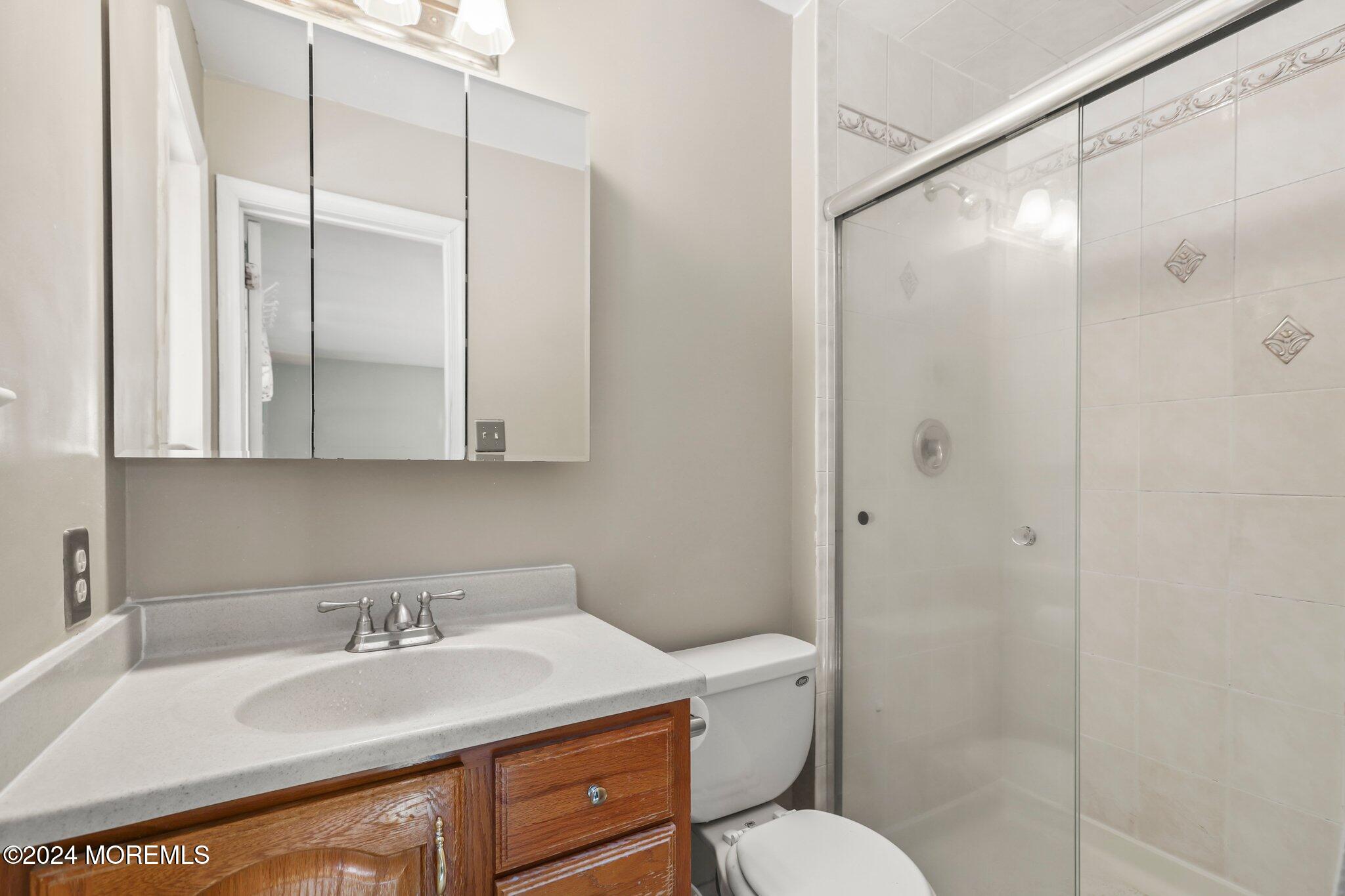 14 Cherry Bend Drive Howell, NJ 07731 - Photo 32 of 47 a bathroom with a granite countertop sink toilet a mirror a shower and vanity