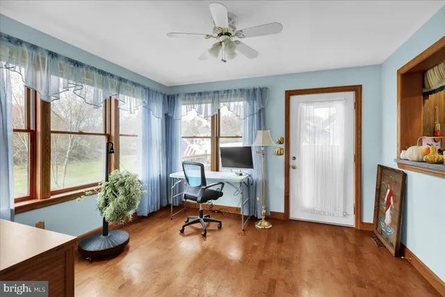 a view of a workspace with furniture and a window