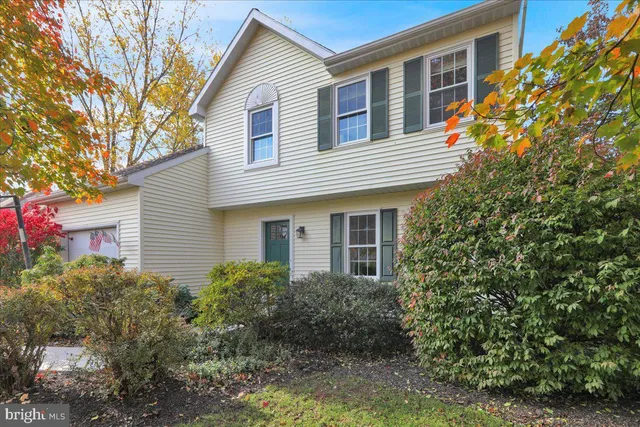 a front view of a house with plants and trees