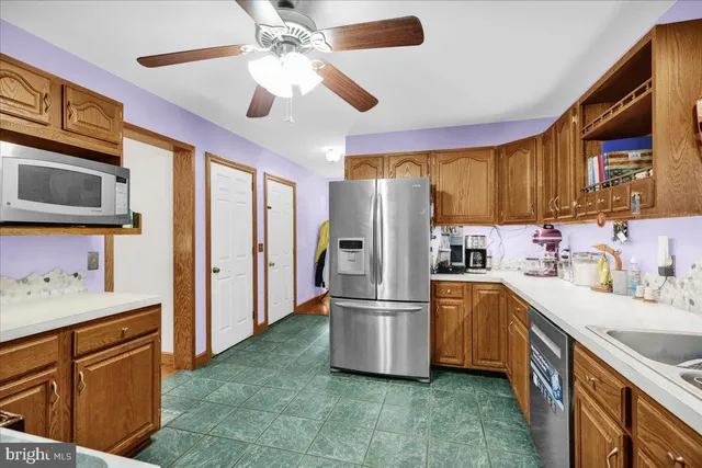a kitchen with stainless steel appliances granite countertop a refrigerator a stove top oven a sink and dishwasher