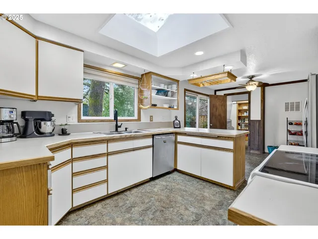 a kitchen with granite countertop a sink stainless steel appliances and cabinets