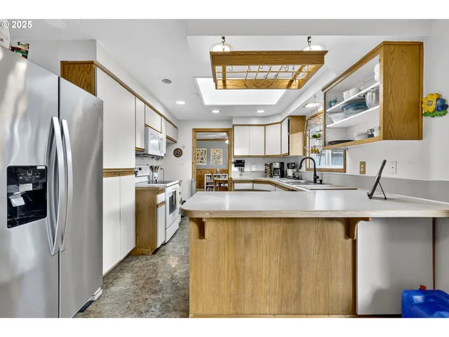 a kitchen with stainless steel appliances granite countertop a sink a refrigerator and a stove