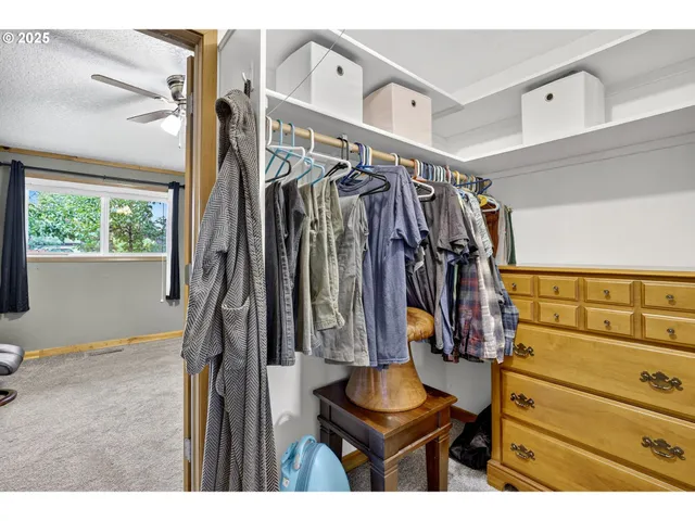 a view of walk in closet with clothes and shoes