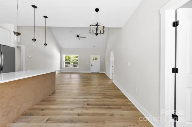 a view of an empty room with window and wooden floor