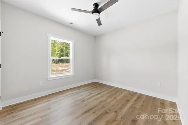 an empty room with a window and a ceiling fan