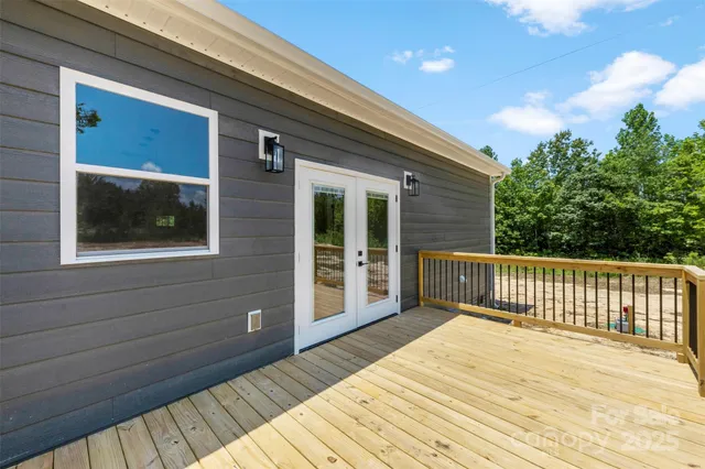 a view of backyard with wooden deck and floor to ceiling window
