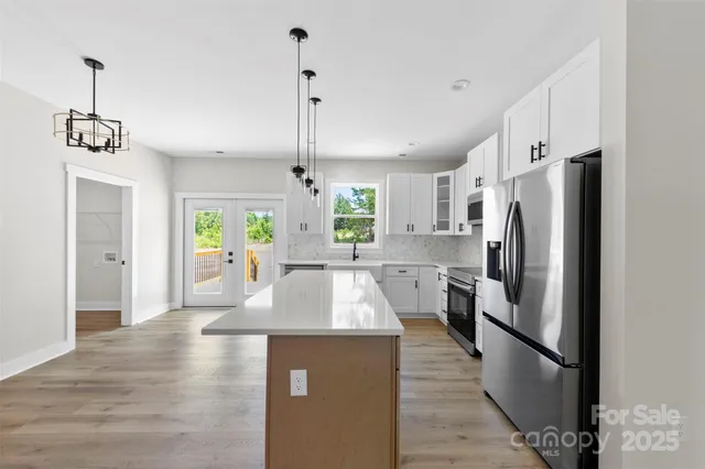 a kitchen with stainless steel appliances granite countertop a refrigerator a sink and a stove