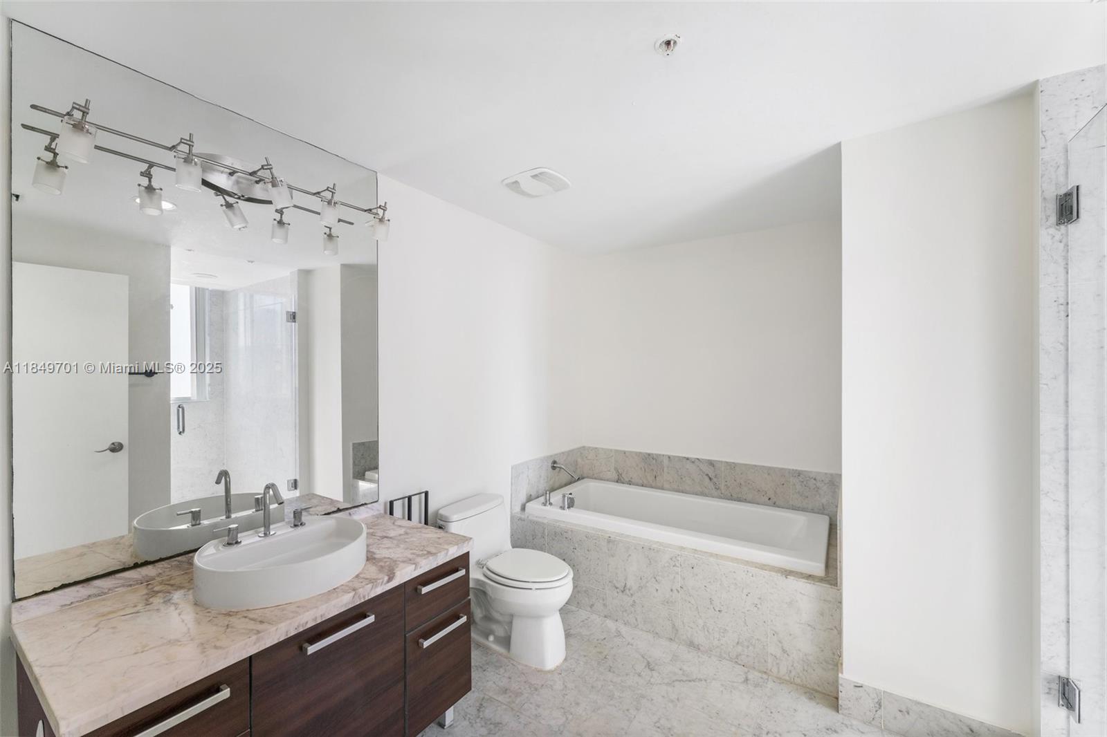 244 Biscayne Boulevard, Unit 1808 Miami, FL 33132 - Photo 13 of 18 a bathroom with a granite countertop sink toilet and shower