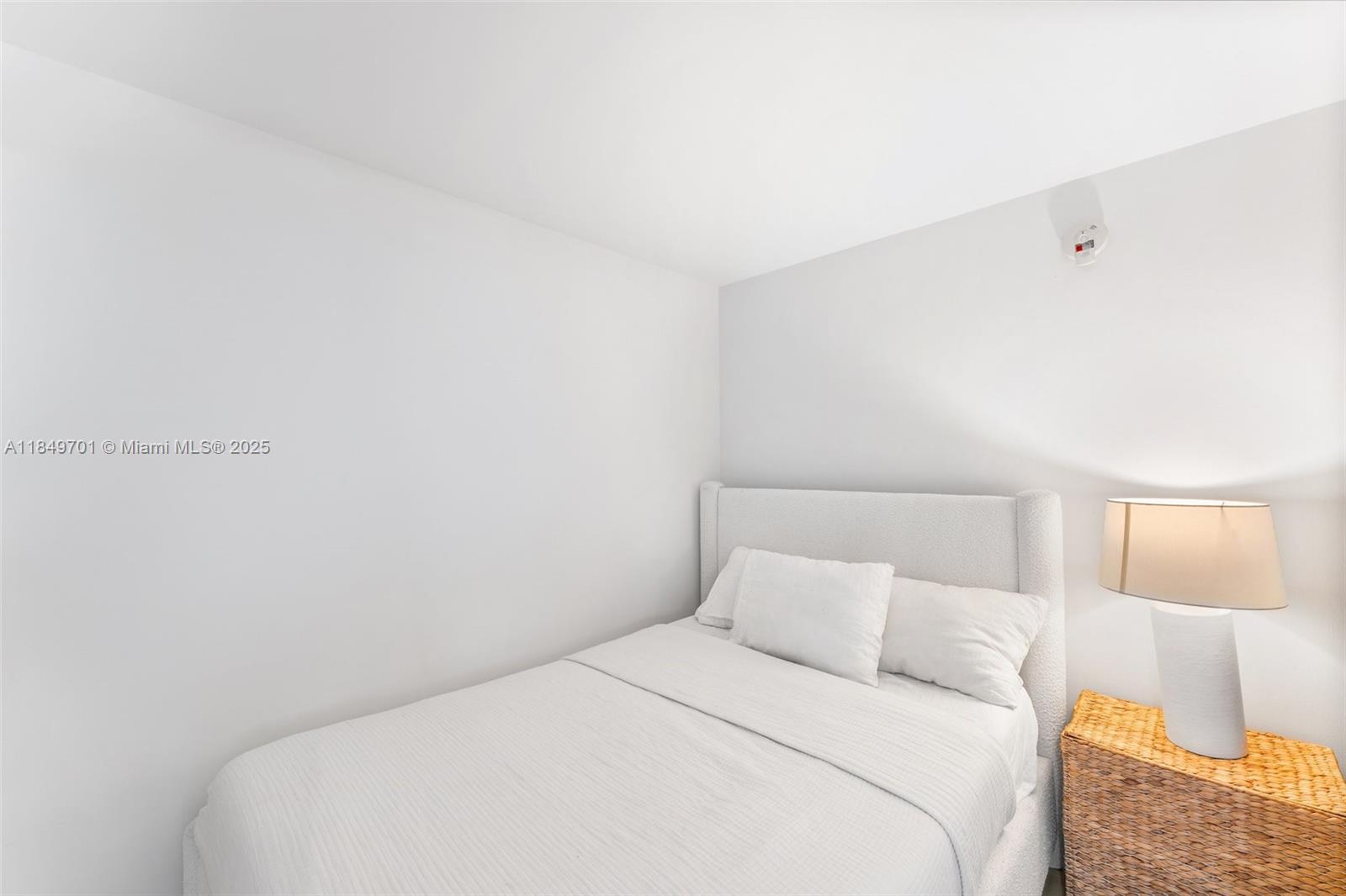 244 Biscayne Boulevard, Unit 1808 Miami, FL 33132 - Photo 7 of 18 a bedroom with a bed and a lamp