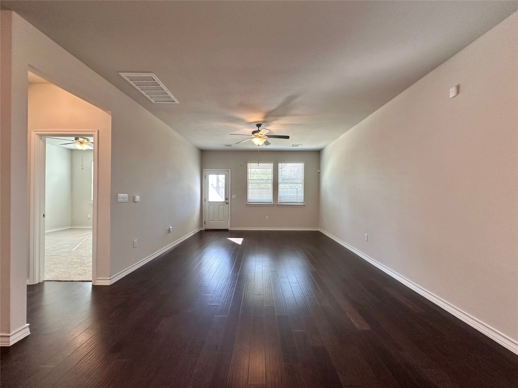 11604 Roxburgh Pass Manor, TX 78653 - Photo 12 of 40 a view of an empty room with wooden floor and a window