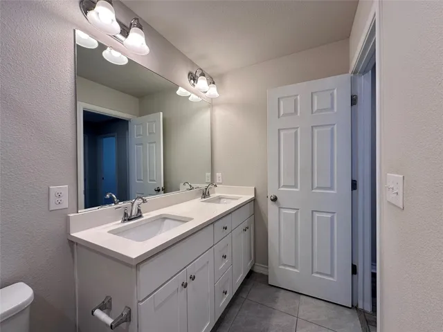 a bathroom with a sink a toilet and a mirror