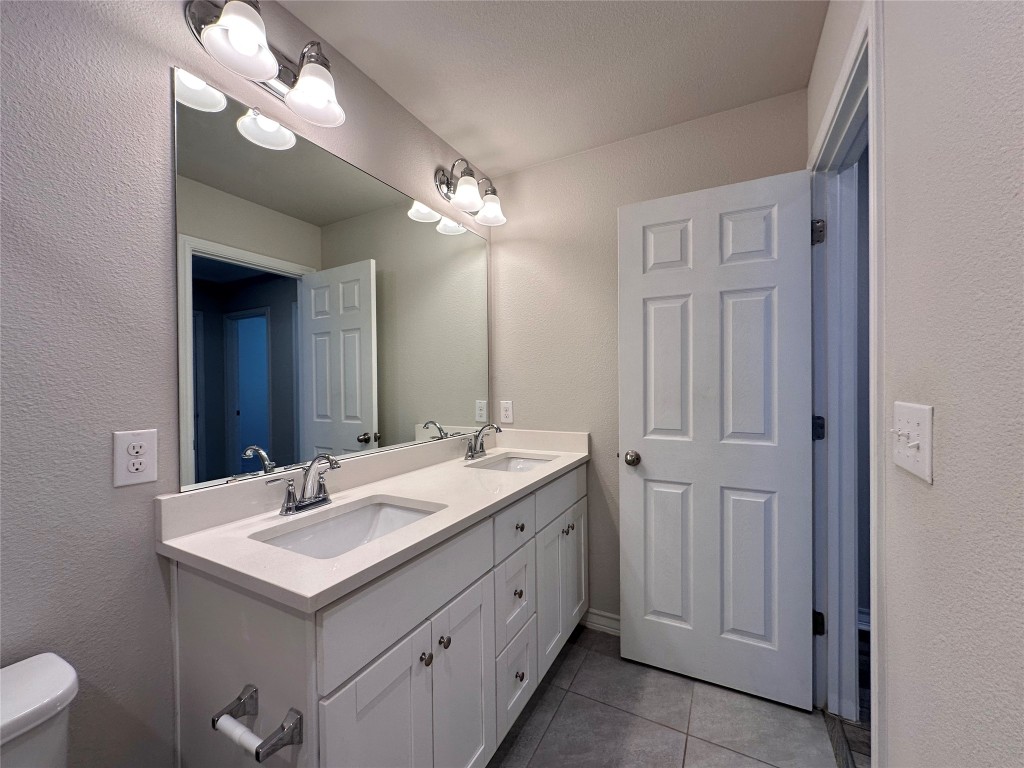 11604 Roxburgh Pass Manor, TX 78653 - Photo 29 of 40 a bathroom with a double vanity sink and a mirror