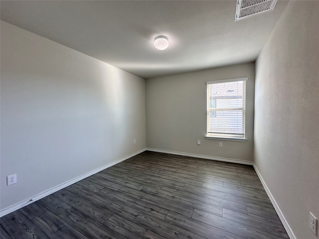 11604 Roxburgh Pass Manor, TX 78653 - Photo 31 of 40 an empty room with wooden floor and windows
