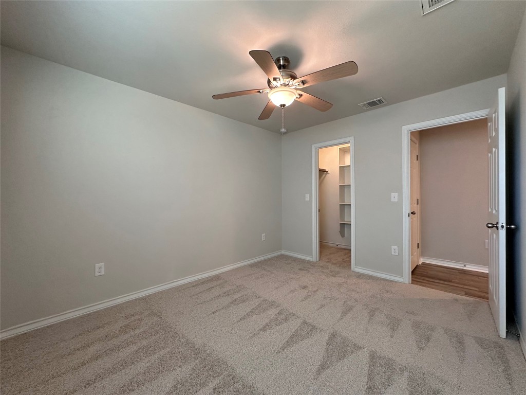 11604 Roxburgh Pass Manor, TX 78653 - Photo 32 of 40 an empty room with closet and a chandelier fan