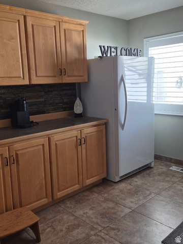 1697 West 2450 Vernal, UT 84078 - Photo 12 of 36 Kitchen featuring dark countertops, freestanding refrigerator, and light wood finish cabinetry
