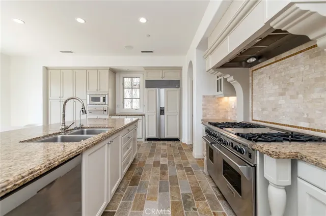 a kitchen with granite countertop a sink stove and cabinets