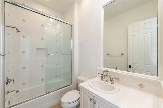 a bathroom with a bathtub shower sink vanity and toilet