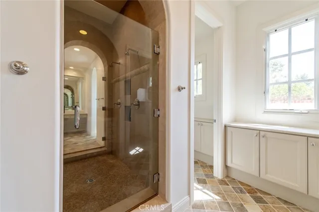 a bathroom with a glass shower door and a window