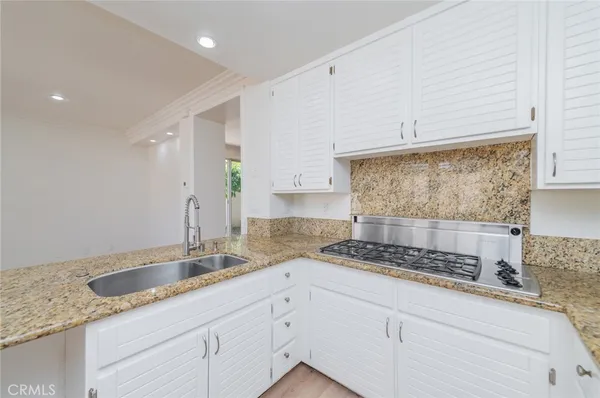 a kitchen with granite countertop a sink stove and cabinets