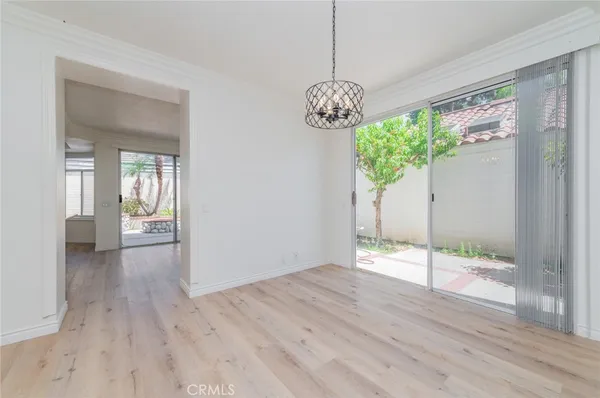 a view of a big room with wooden floor and a chandelier