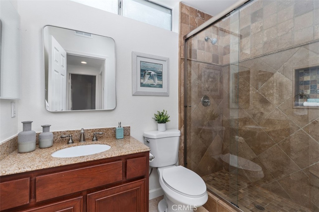 24882 Summerwind Dana Point, CA 92629 - Photo 19 of 31 a bathroom with a granite countertop sink toilet a mirror and shower