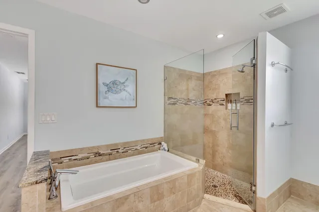 a large bathroom with a granite countertop tub sink a toilet a mirror and shower