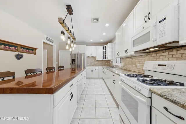 a large kitchen with stainless steel appliances kitchen island granite countertop a sink and cabinets