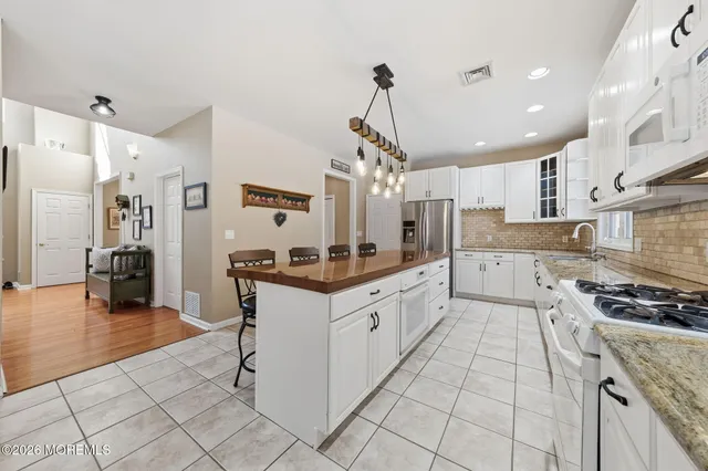 a kitchen with stainless steel appliances granite countertop a sink a stove a refrigerator and cabinets