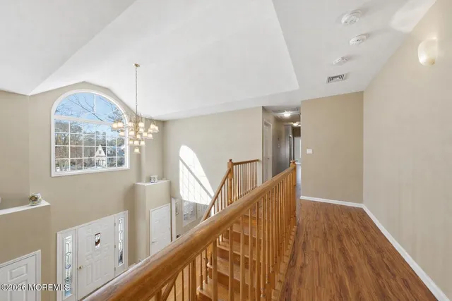a view of a hallway with wooden floor and staircase