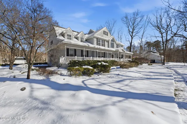 a view of a white house with a yard covered in snow