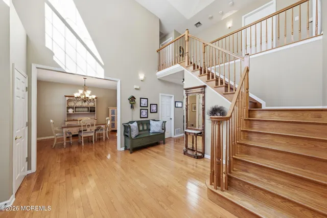 a view of staircase with railing and chandelier