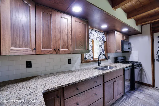 a kitchen with stainless steel appliances granite countertop wooden cabinets a sink and dishwasher