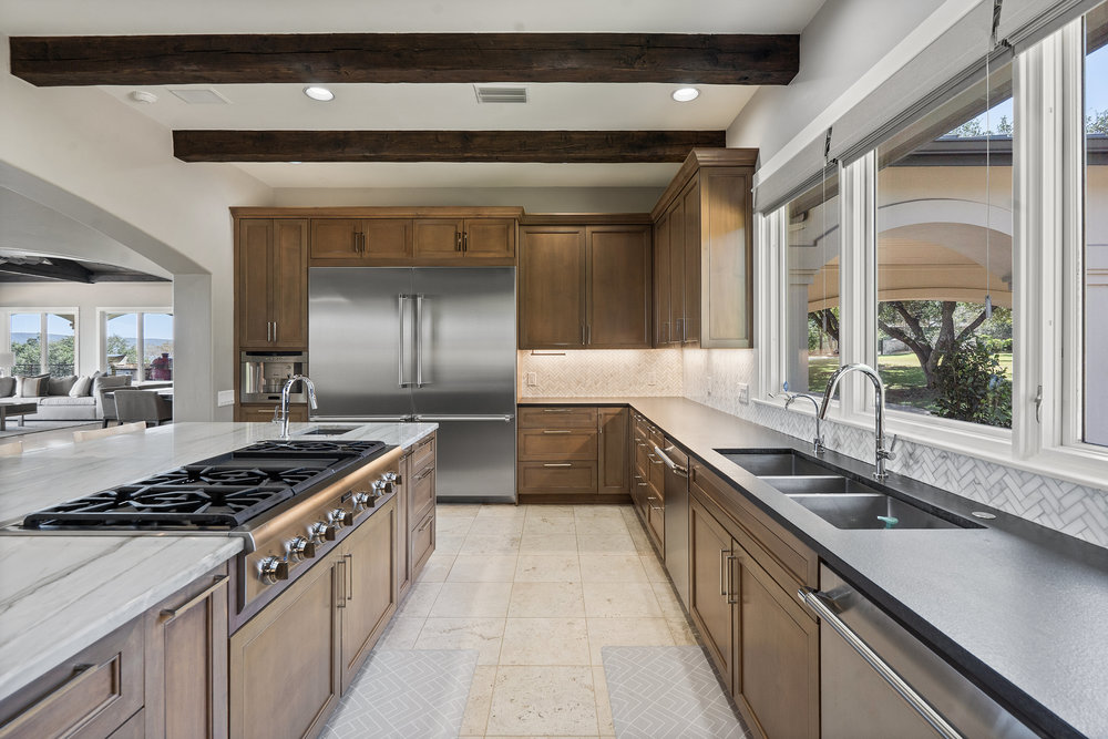 15210 Rainbow 1 Street Austin, TX 78734 - Photo 21 of 40 a kitchen with stainless steel appliances a sink stove and cabinets