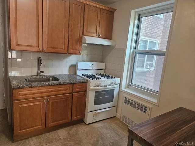 a kitchen with stainless steel appliances granite countertop a stove a sink and a microwave