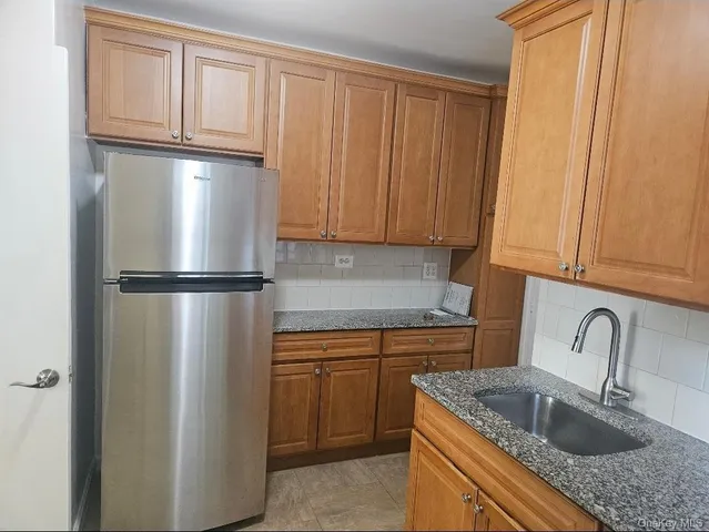 a kitchen with stainless steel appliances granite countertop a refrigerator a sink and dishwasher