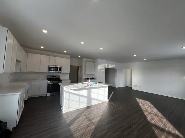 a large kitchen with kitchen island a sink a stove a center island a stove and a cabinets