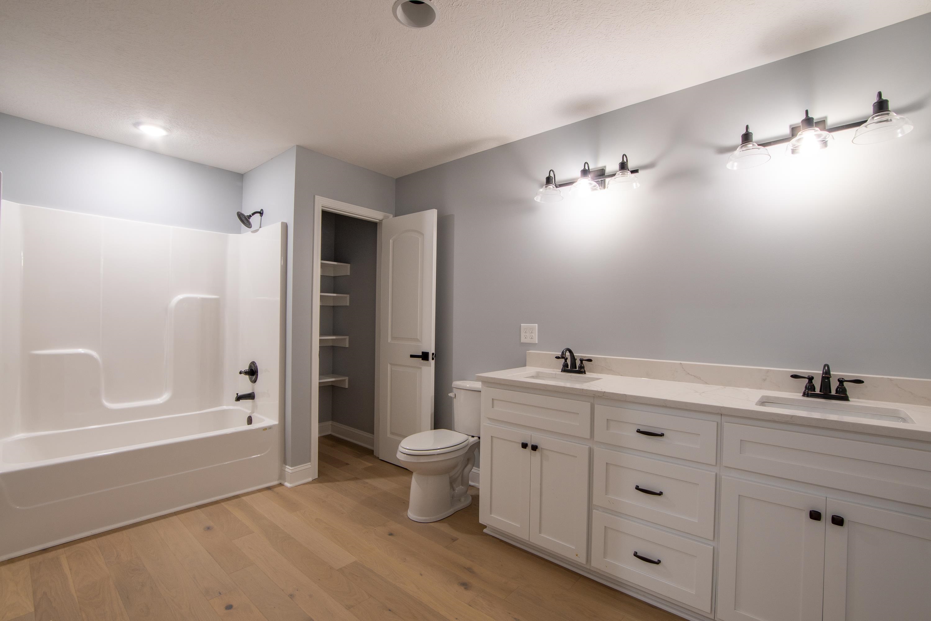 260 Range Road Savannah, TN 38372 - Photo 16 of 40 a bathroom with a double vanity sink a toilet and shower