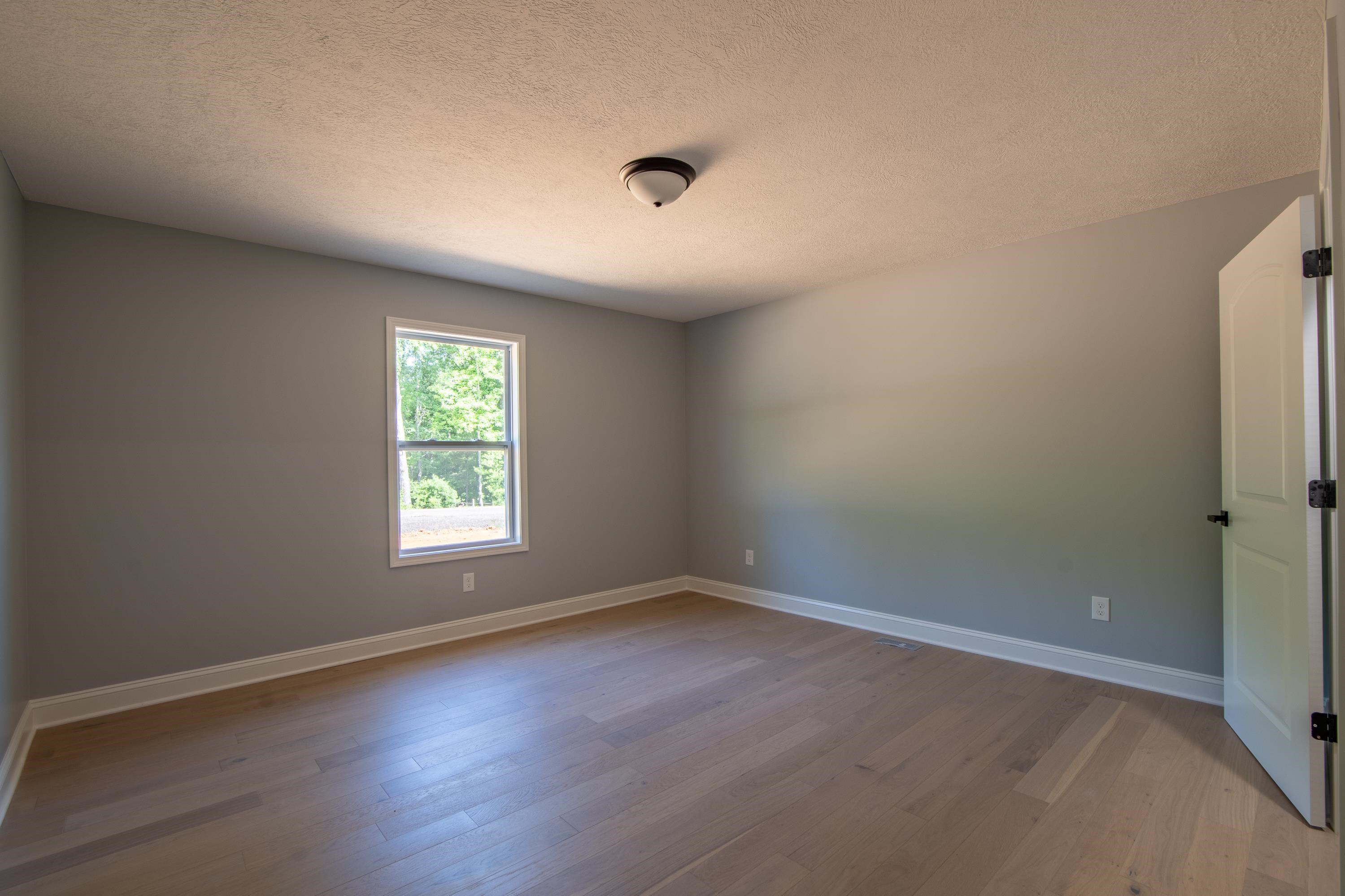 260 Range Road Savannah, TN 38372 - Photo 19 of 40 an empty room with wooden floor and windows